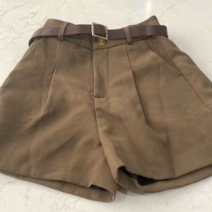 High waisted pleated shorts in a khaki brown color.